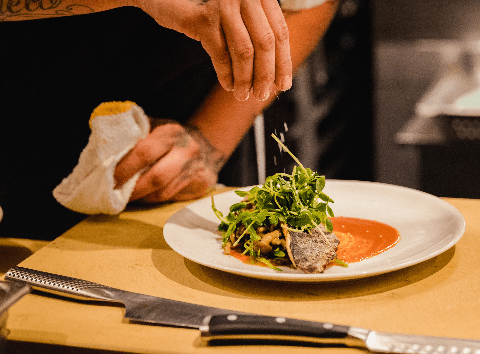 Professional chef plating gourmet food with artistic presentation